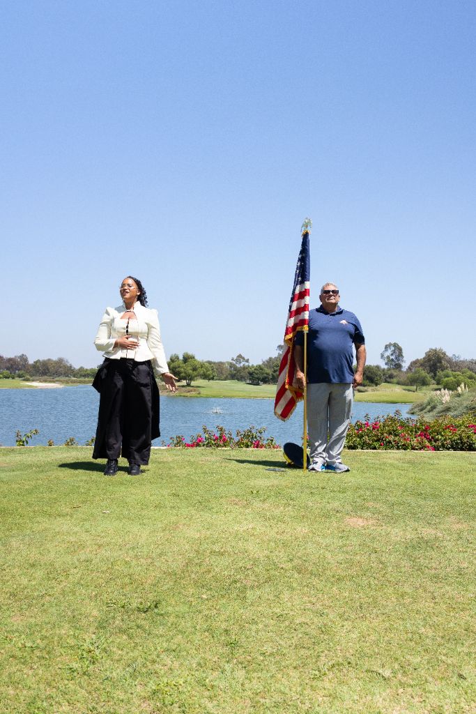 Hannah Humphrey sings the national anthem with U.S. Army Captain Nick Saifan as flag-bearer at Old Ranch Country Club