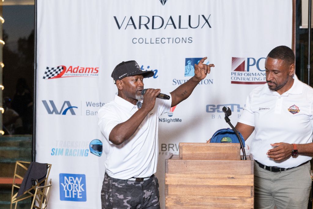 Comedian Joe Torry delivering a closing message at the podium during the awards banquet